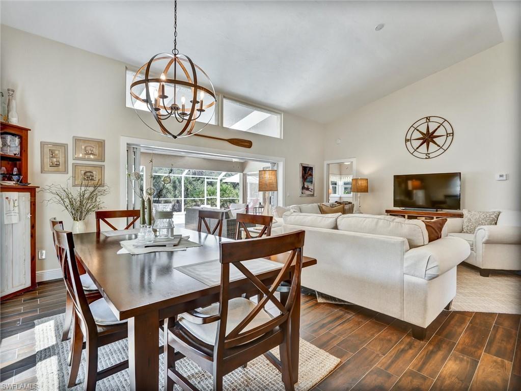 421 Countryside Drive Naples, FL 34104 - Photo 17 of 44 Dining room featuring wood tiled floors, high vaulted ceiling, and a chandelier