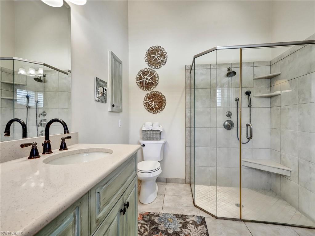 421 Countryside Drive Naples, FL 34104 - Photo 21 of 44 Full Primary bath featuring vanity, a stall shower, and light tile patterned flooring