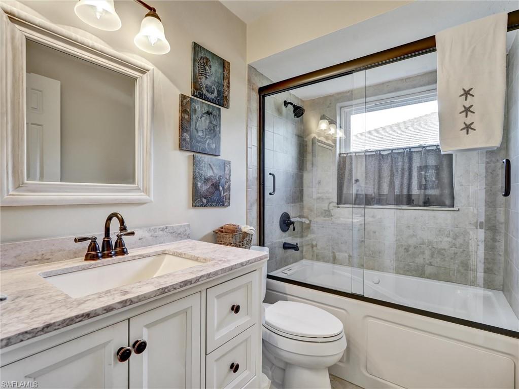 421 Countryside Drive Naples, FL 34104 - Photo 27 of 44 Full Guest bathroom featuring bath / shower combo with glass door and vanity