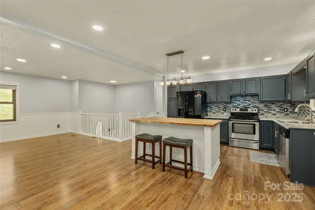a kitchen with a sink a counter top space stainless steel appliances and cabinets