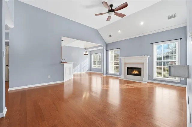 a view of empty room with wooden floor and fireplace