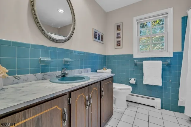 a bathroom with a granite countertop sink a mirror and a toilet