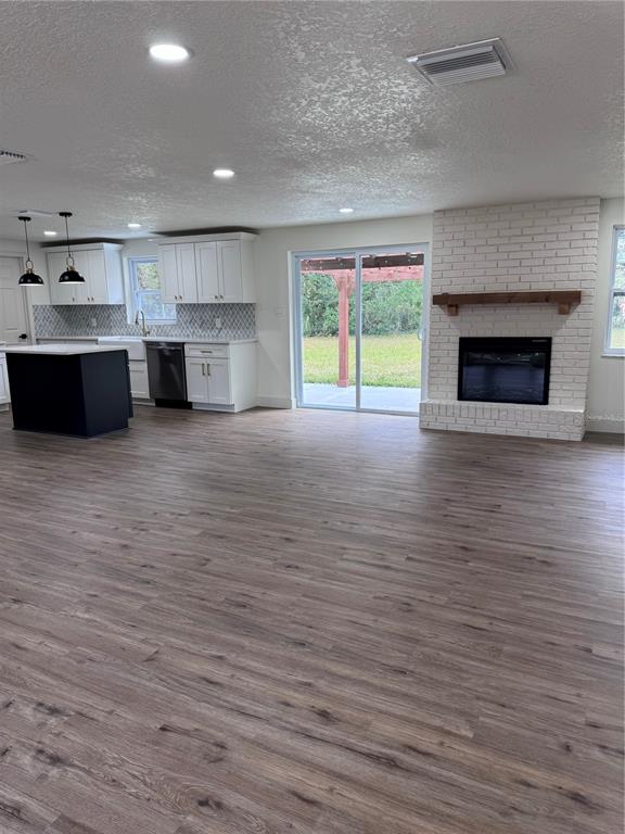 2933 Stearns Road Valrico, FL 33596 - Photo 6 of 16 a view of a kitchen with kitchen island a sink wooden floor and a fireplace
