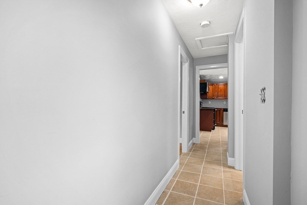19 Forest Drive Auburn, MA 01501 - Photo 11 of 31 a hallway with wooden floor and a bathroom