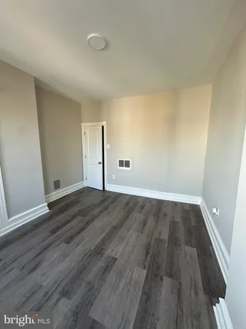an empty room with wooden floor and door