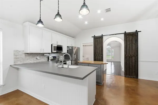 a kitchen with stainless steel appliances granite countertop a sink refrigerator and microwave