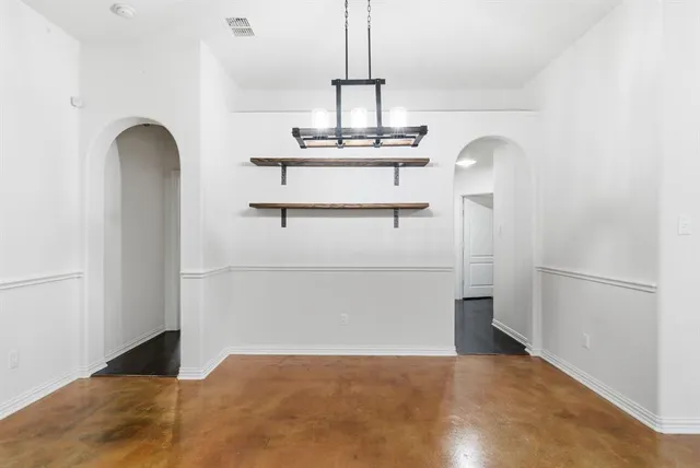 a view of an empty room with a window and fireplace
