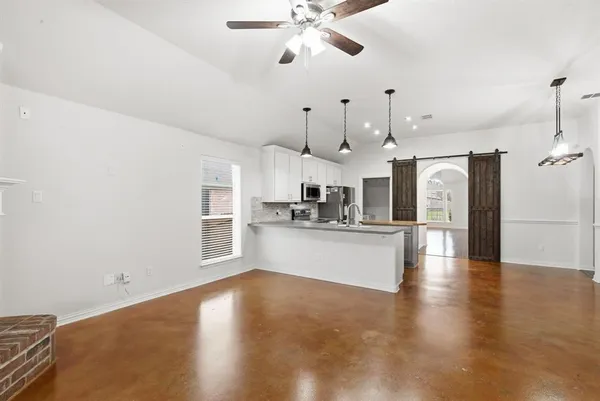 a view of a kitchen with a sink and refrigerator