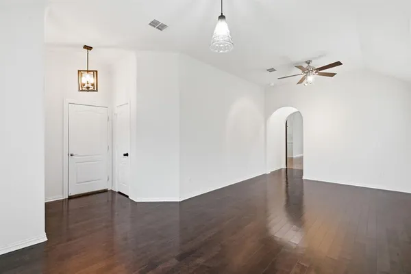 an empty room with wooden floor chandelier fan and closet