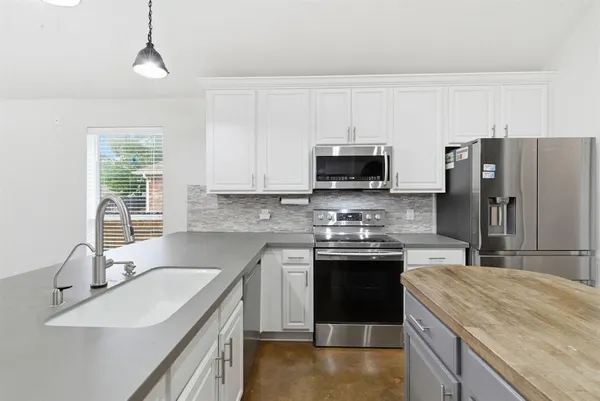 a kitchen with stainless steel appliances granite countertop a sink stove and refrigerator