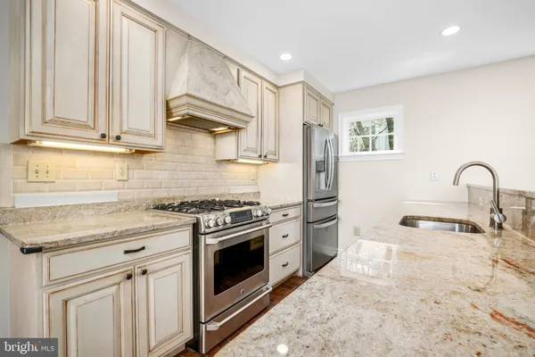 a kitchen with stainless steel appliances granite countertop a stove a sink and a microwave