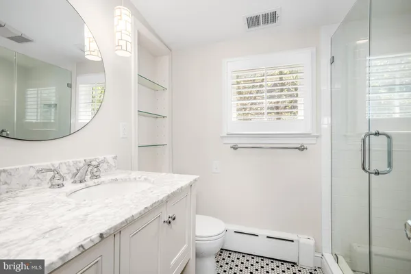 a bathroom with a granite countertop sink toilet and shower