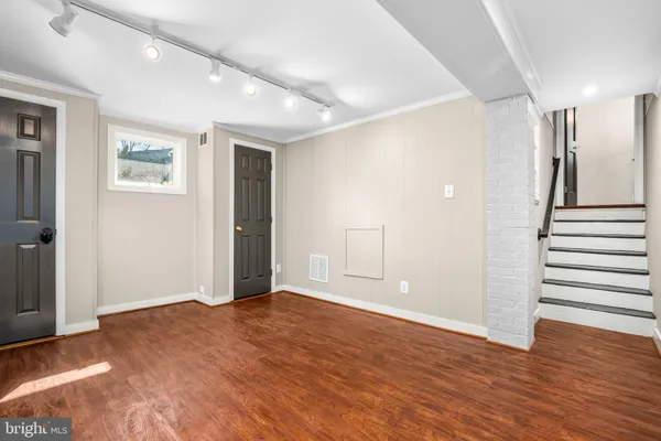 a view of an empty room with wooden floor