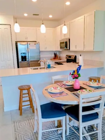 a kitchen with stainless steel appliances granite countertop a stove a kitchen island a sink a stove and white cabinets