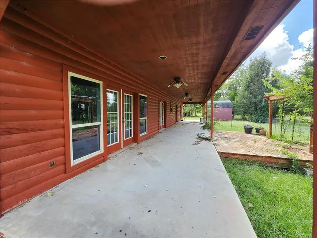 a view of a porch with wooden floor and fence