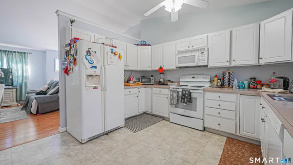 a kitchen with white cabinets and white appliances