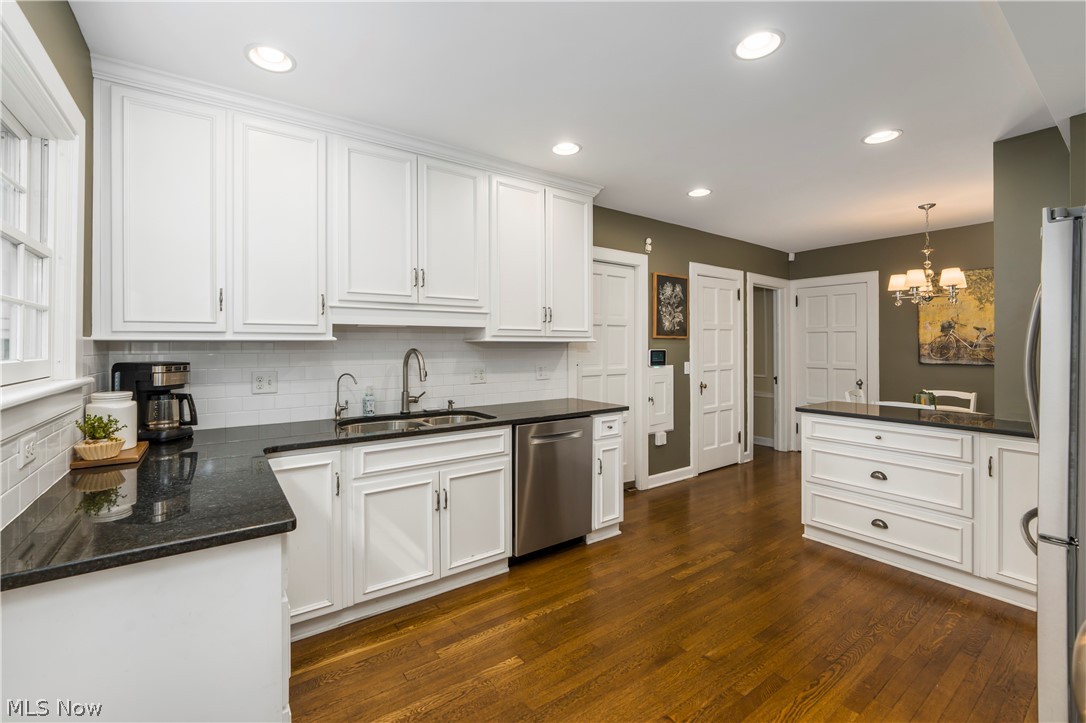 2960 Midvale Road Northwest Canton, OH 44718 - Photo 11 of 42 Kitchen with dark hardwood / wood-style floors, stainless steel appliances, tasteful backsplash, white cabinetry, and sink