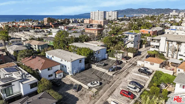 a view of a small house with wooden fence
