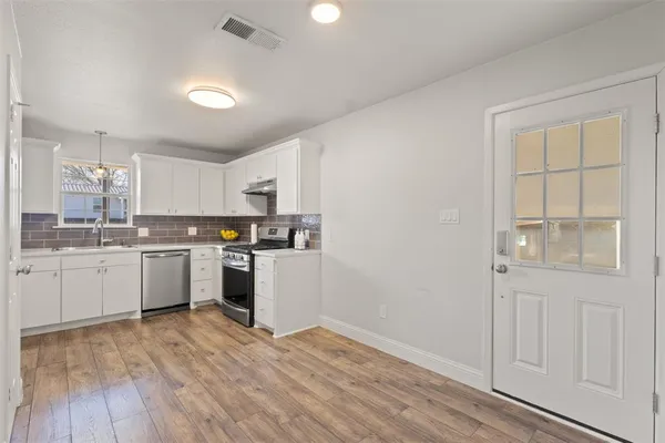 a kitchen with granite countertop white cabinets and white appliances