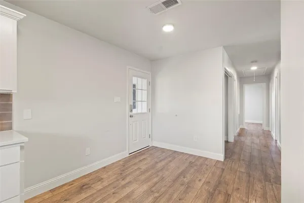 a view of a room with wooden floor