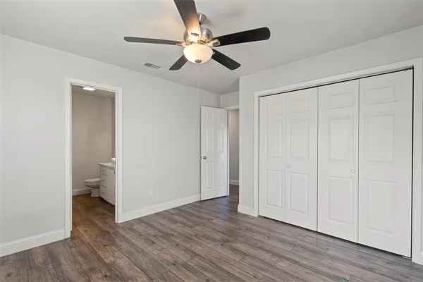 an empty room with wooden floor a ceiling fan