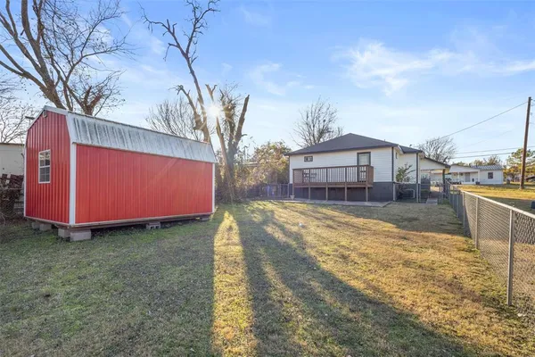 a view of a house with a yard and wooden fence