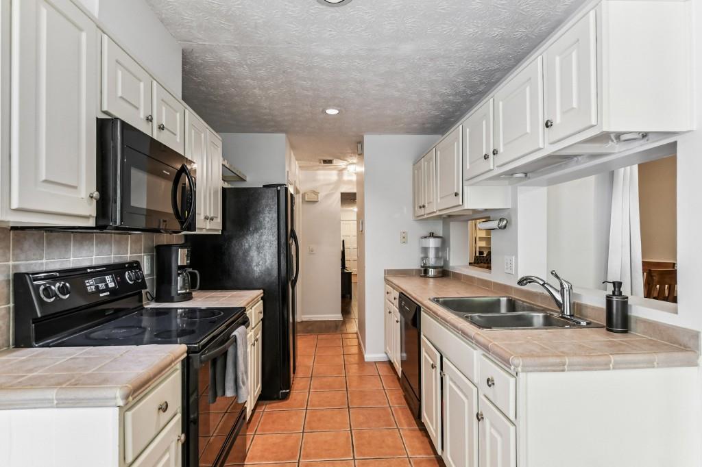 19 Normandy Court Atlanta, GA 30324 - Photo 13 of 27 a kitchen with stainless steel appliances granite countertop a sink stove and refrigerator
