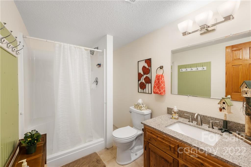 80 Lick Log Road Sylva, NC 28779 - Photo 12 of 25 a bathroom with a granite countertop sink mirror vanity and toilet