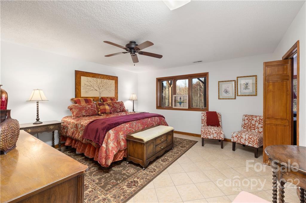 80 Lick Log Road Sylva, NC 28779 - Photo 16 of 25 a spacious bedroom with a bed a window and dresser