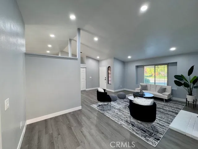 a living room with couches chairs and a potted plant