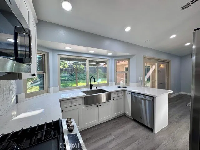 a large kitchen with a large window and stainless steel appliances