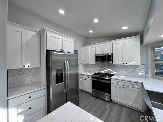 a kitchen with granite countertop a refrigerator and a stove top oven