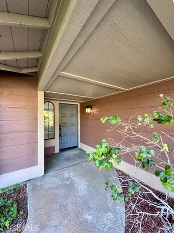 a view of a porch with a floor to ceiling window and potted plants