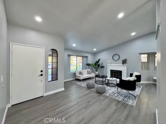 a living room with fireplace furniture and a wooden floor