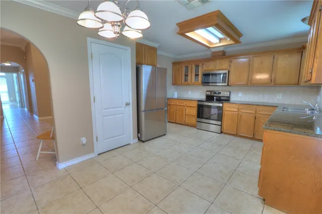 a kitchen with stainless steel appliances granite countertop a refrigerator stove and sink