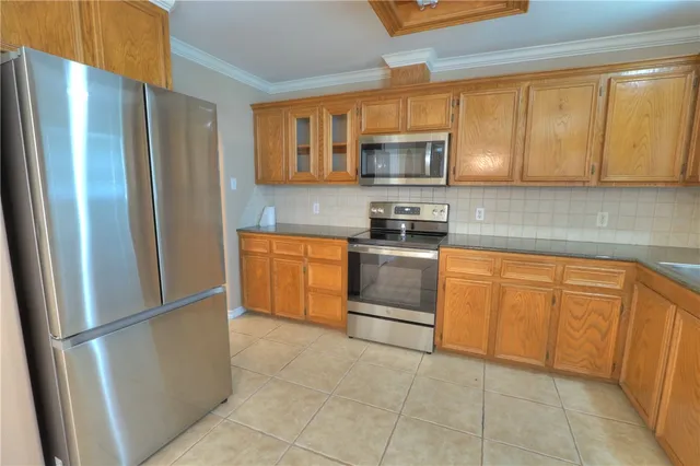 a metallic refrigerator freezer sitting in a kitchen