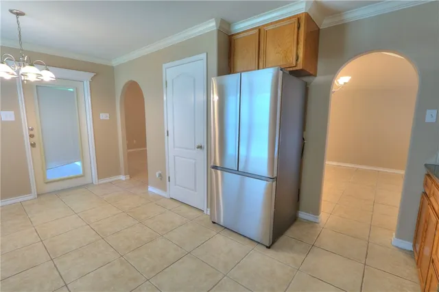 an empty room with windows and chandelier fan