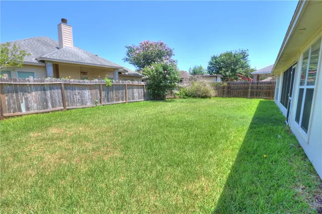 a view of a house with a yard and sitting area