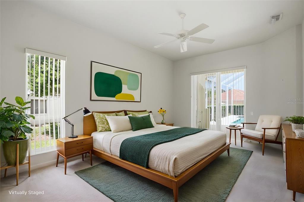 7221 Aloe Drive Spring Hill, FL 34607 - Photo 13 of 34 a bedroom with a bed a couch and potted plant with two window