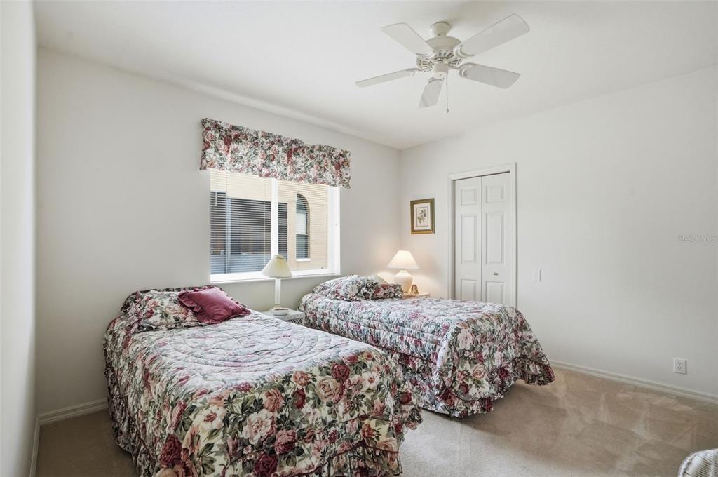 7221 Aloe Drive Spring Hill, FL 34607 - Photo 21 of 34 a bedroom with two beds and a chandelier