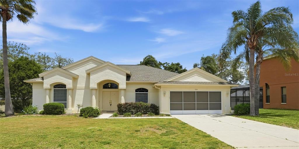 7221 Aloe Drive Spring Hill, FL 34607 - Photo 3 of 34 a front view of a house with a yard