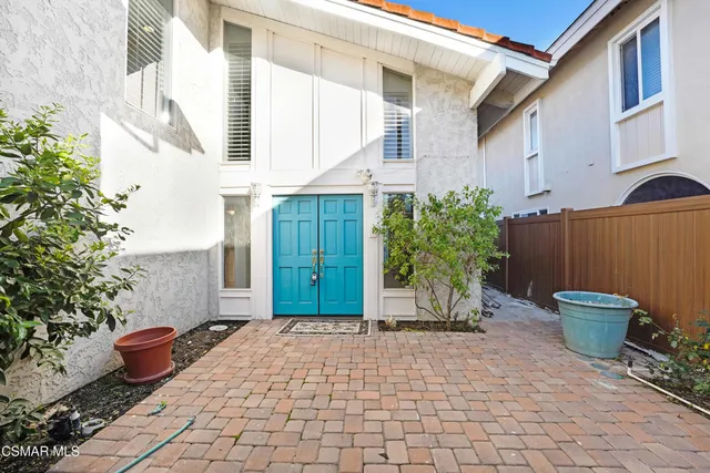 a view of a backyard of the house with potted plants