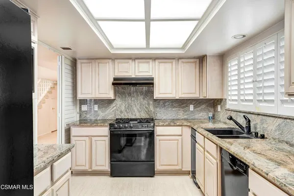 a kitchen with a sink stove top oven and cabinets