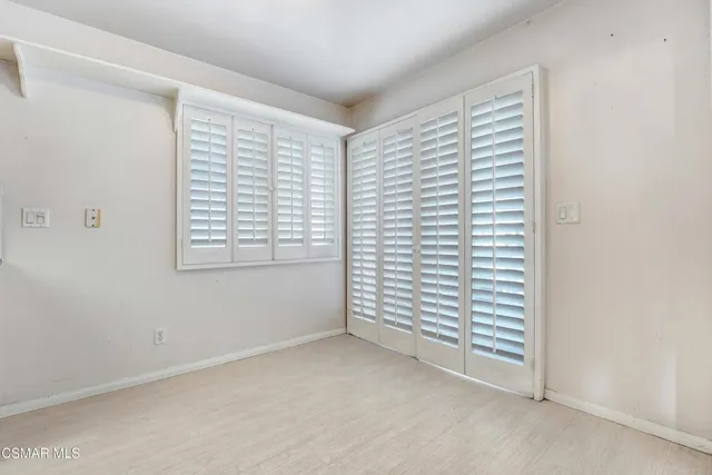 a dining room with furniture a potted plant and kitchen view