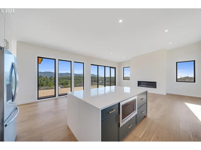 a kitchen with stainless steel appliances granite countertop a stove a sink and a refrigerator with wooden floor