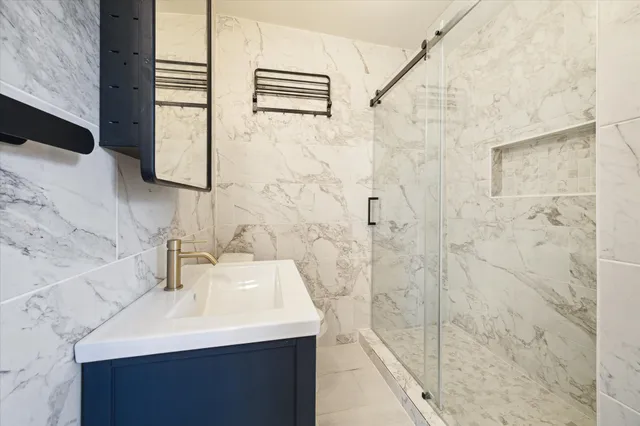 a bathroom with a sink a shower and a mirror