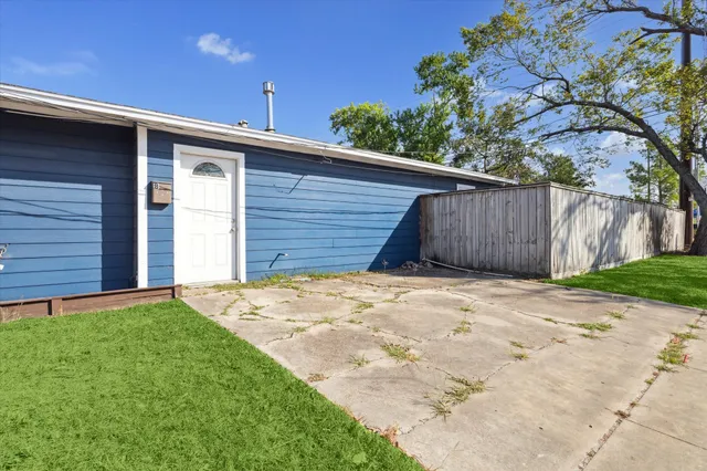 a view of yellow house with wooden fence