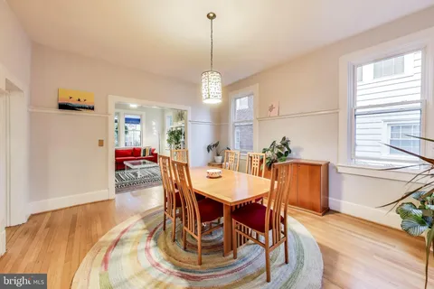 a dining room with furniture potted plants and wooden floor