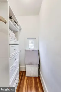 a view of a bedroom with wooden floor and a window