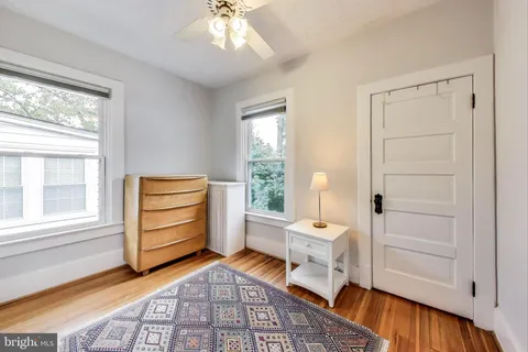 a spacious bedroom with a bed and wooden floor